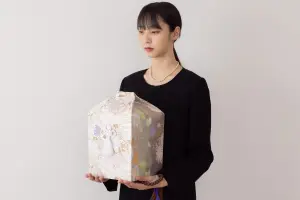 骨壺を持つ女性