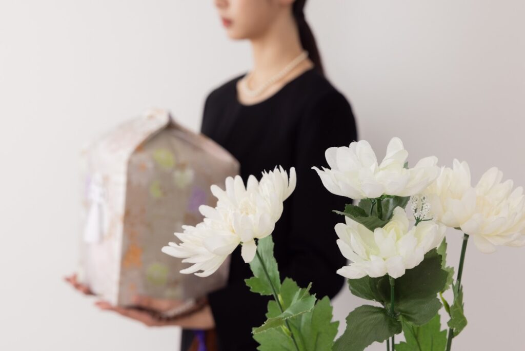 骨壺を持つ女性