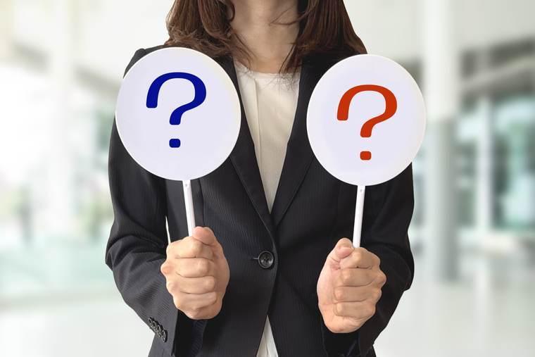 2つのはてなマークを持つスーツの女性