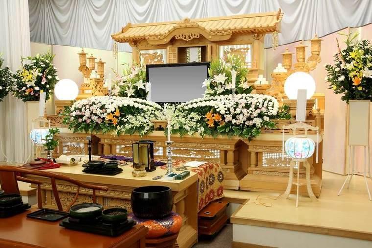 白い花で飾られた葬儀式場の祭壇
