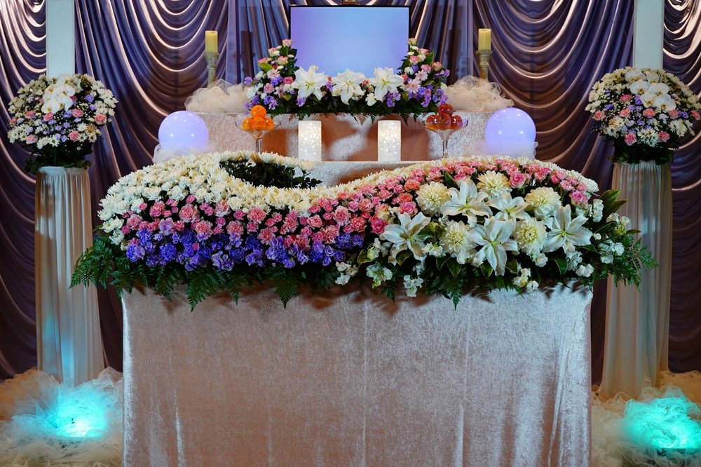 白と紫の花で飾られた葬儀の祭壇