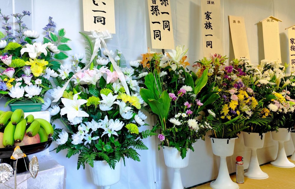 供花と芳名札が並ぶ通夜の会場