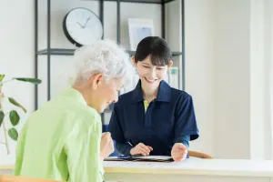 スタッフと打ち合わせをする高齢女性