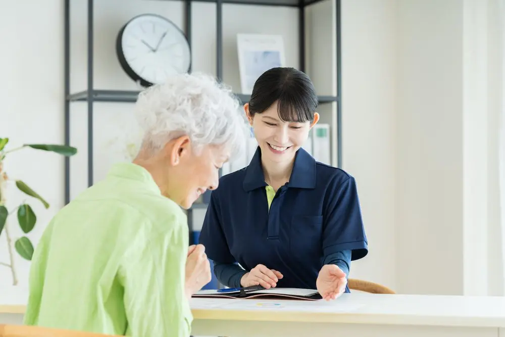 スタッフと打ち合わせをする高齢女性